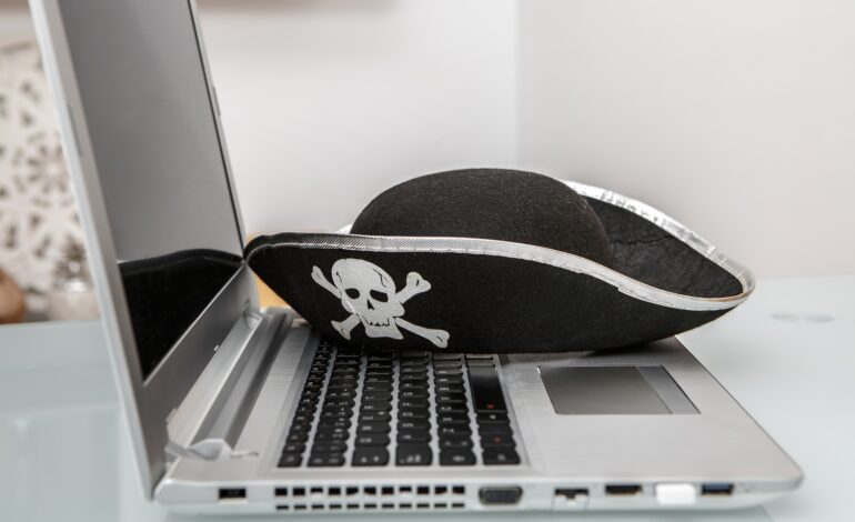 Creative Representation of Hacking and Online Scams With Pirate Hat on Laptop