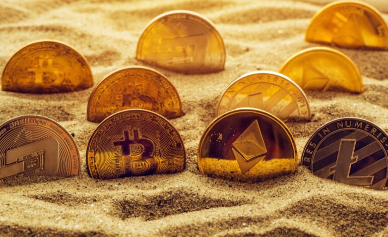 Cryptocurrency coins in sand